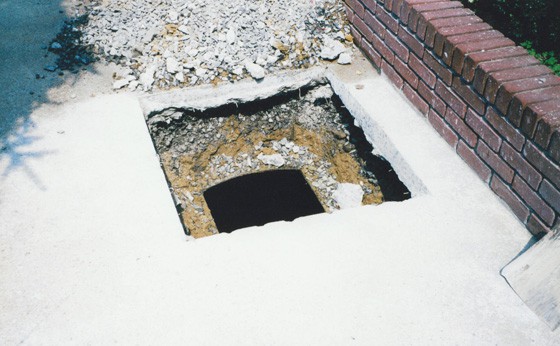 ABADONMENT of a buried 550-gallon tank under concrete next to brick wall.  Tank cannot be removed.