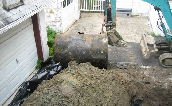 550 gallon removal in front of the garage under driveway